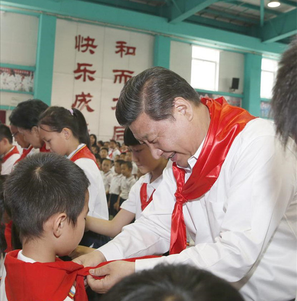 2014年5月30日，在北京市海淀區(qū)民族小學(xué)的少先隊(duì)入隊(duì)儀式上，習(xí)近平為新少先隊(duì)員系上紅領(lǐng)巾。